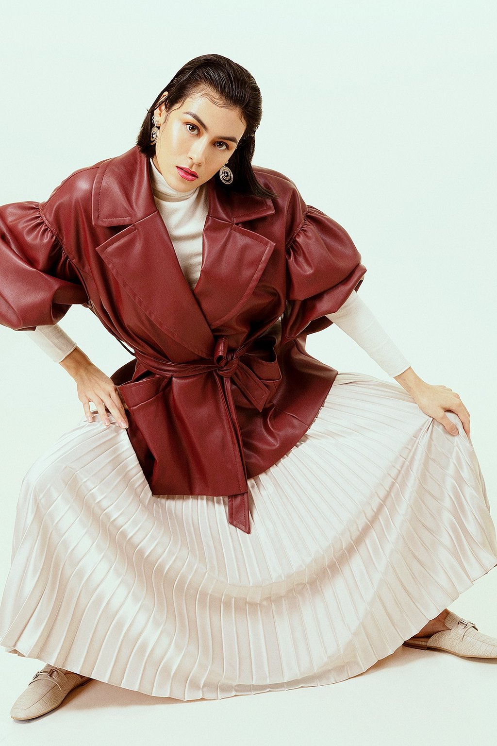 modèle femme avec manteau cuir rouge en studio