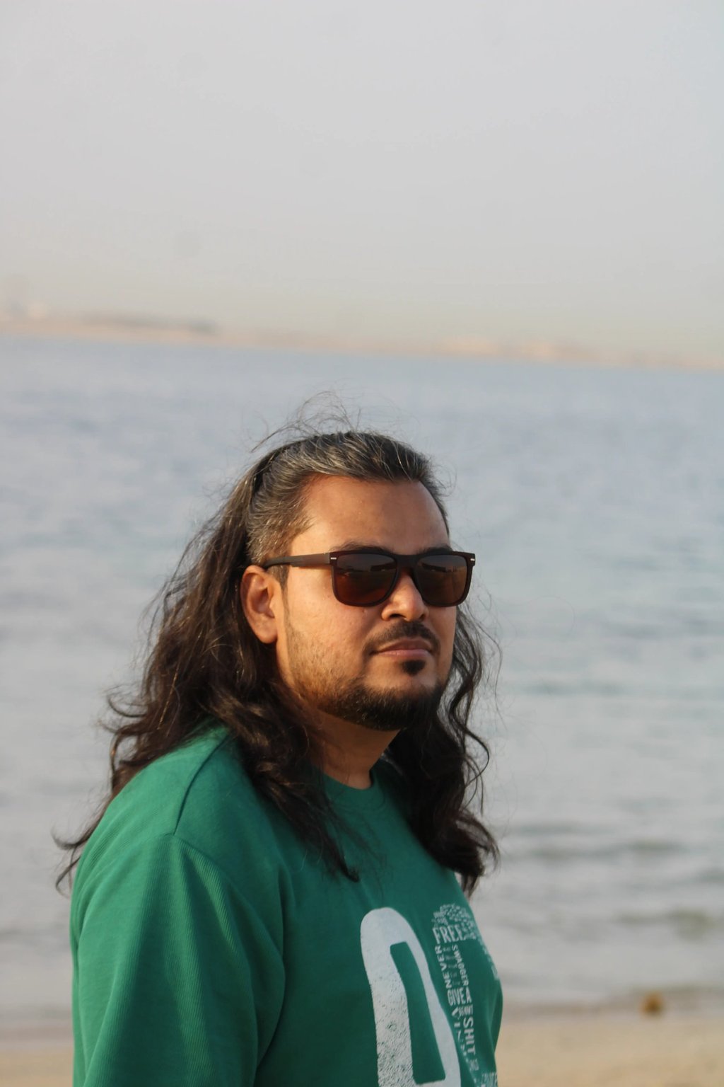 ध्यानपूर्ण मुद्रा में समुद्र की ओर देखते हुए एक व्यक्ति – आत्म-चिंतन और शांति की झलक