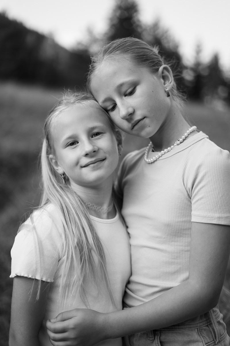 Two girls sisters hugging each other in black and white image
