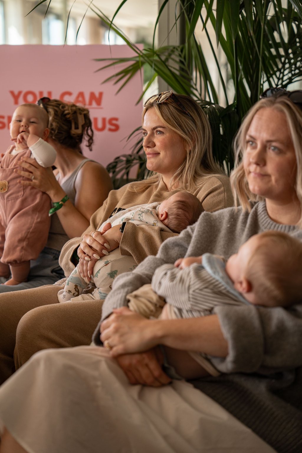 photo of women holding their babies in the arms and smiling 