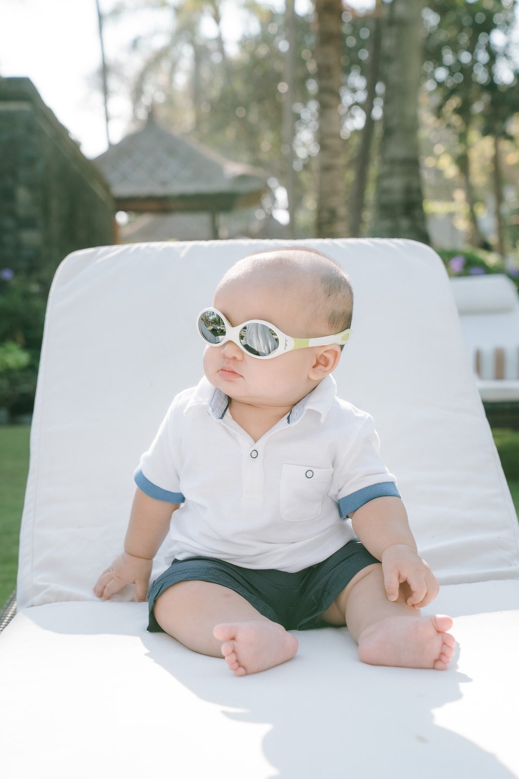 Baby sitting on sunbed at Intercontinental Jimbaran captured in a soft and playful family photography moment
