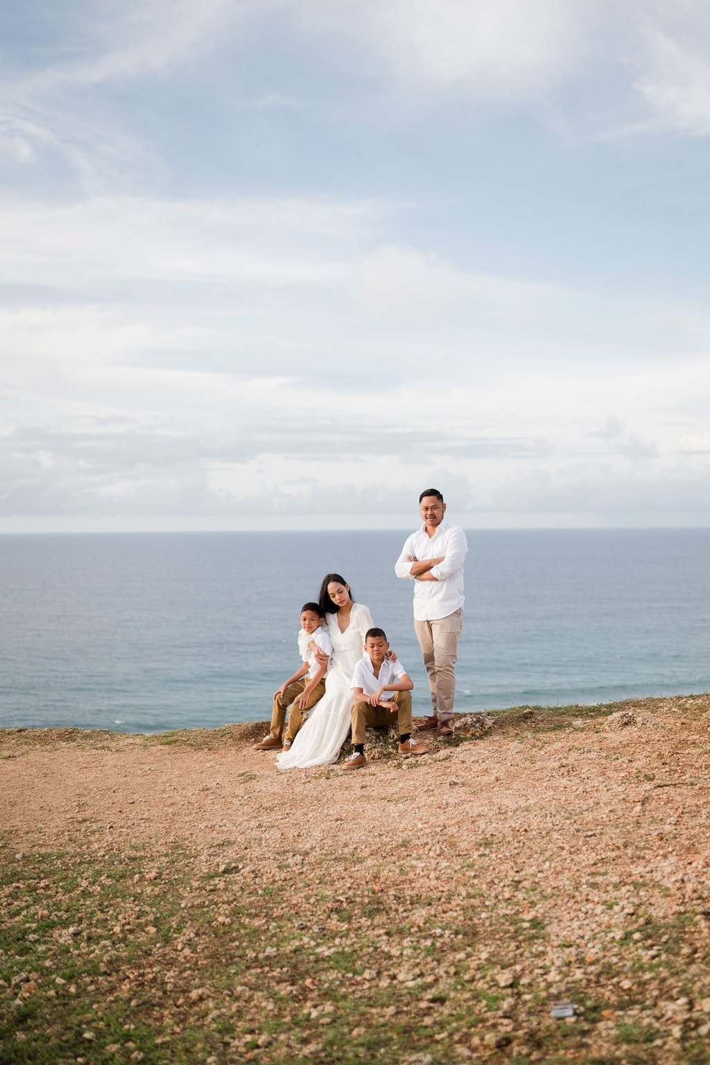 Wide cliffside view of Ayunda family enjoying the ocean backdrop at Melasti Beach Bali.