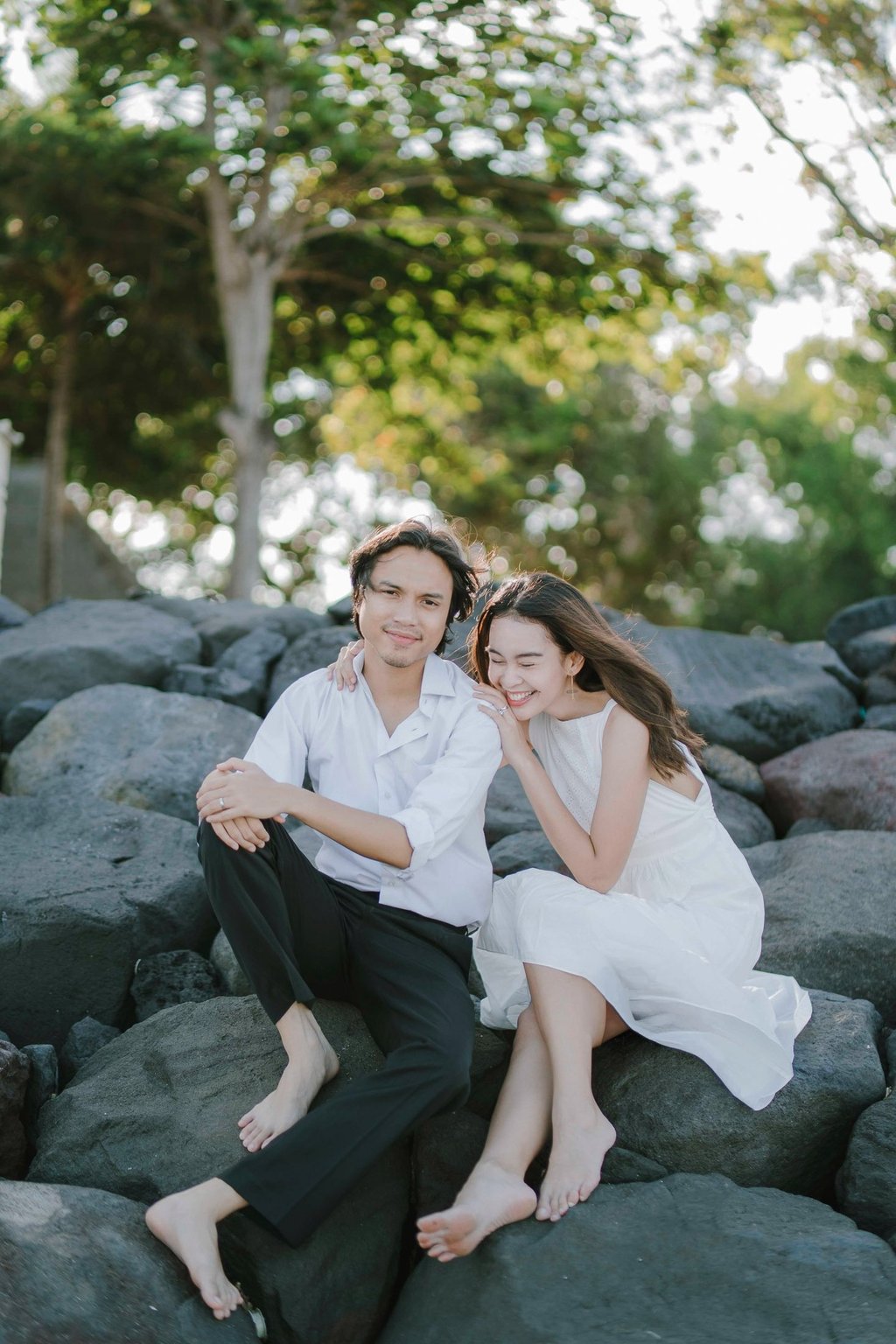 Intimate couple sitting on rocks during sunset session at Novotel Tanjung Benoa Bali.