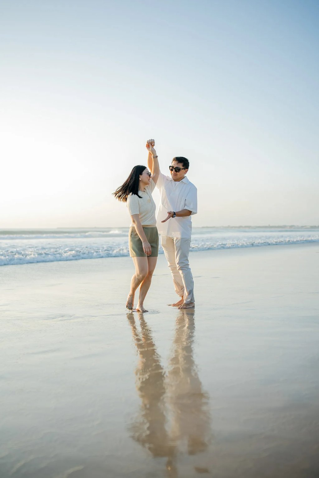 Parents walking together along the shoreline during a family photography session at InterContinental Bali Resort