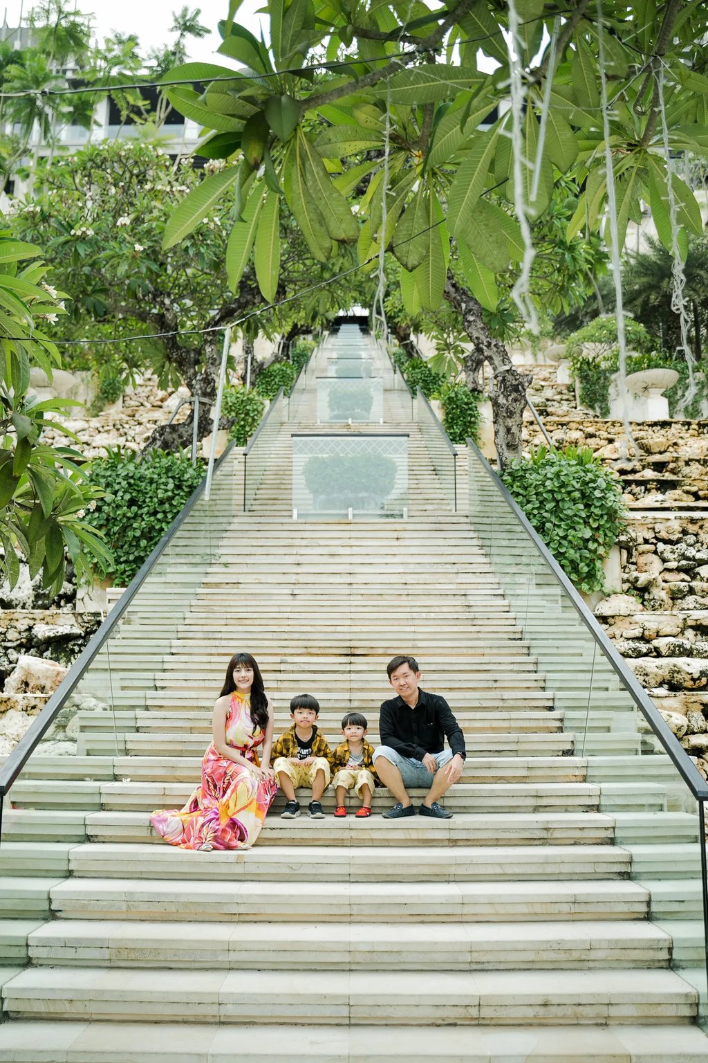 Family photography session on the Grand Staircase at The Apurva Kempinski Bali overlooking the Indian Ocean
