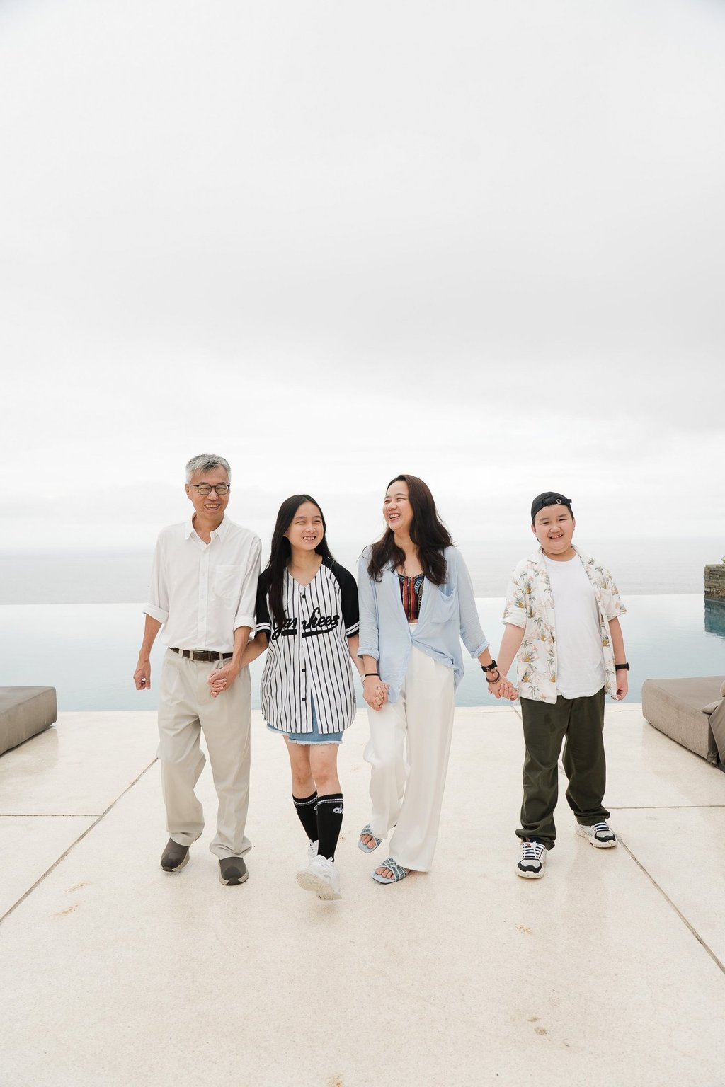 Family walking together at Alila Villas Uluwatu Bali with minimal architecture and soft tones