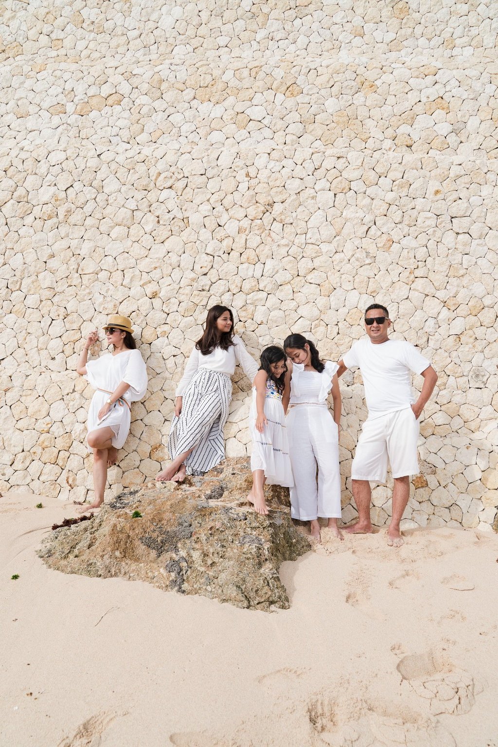Extended family portrait on the beach with cliff backdrop at Karma Kandara Bali  