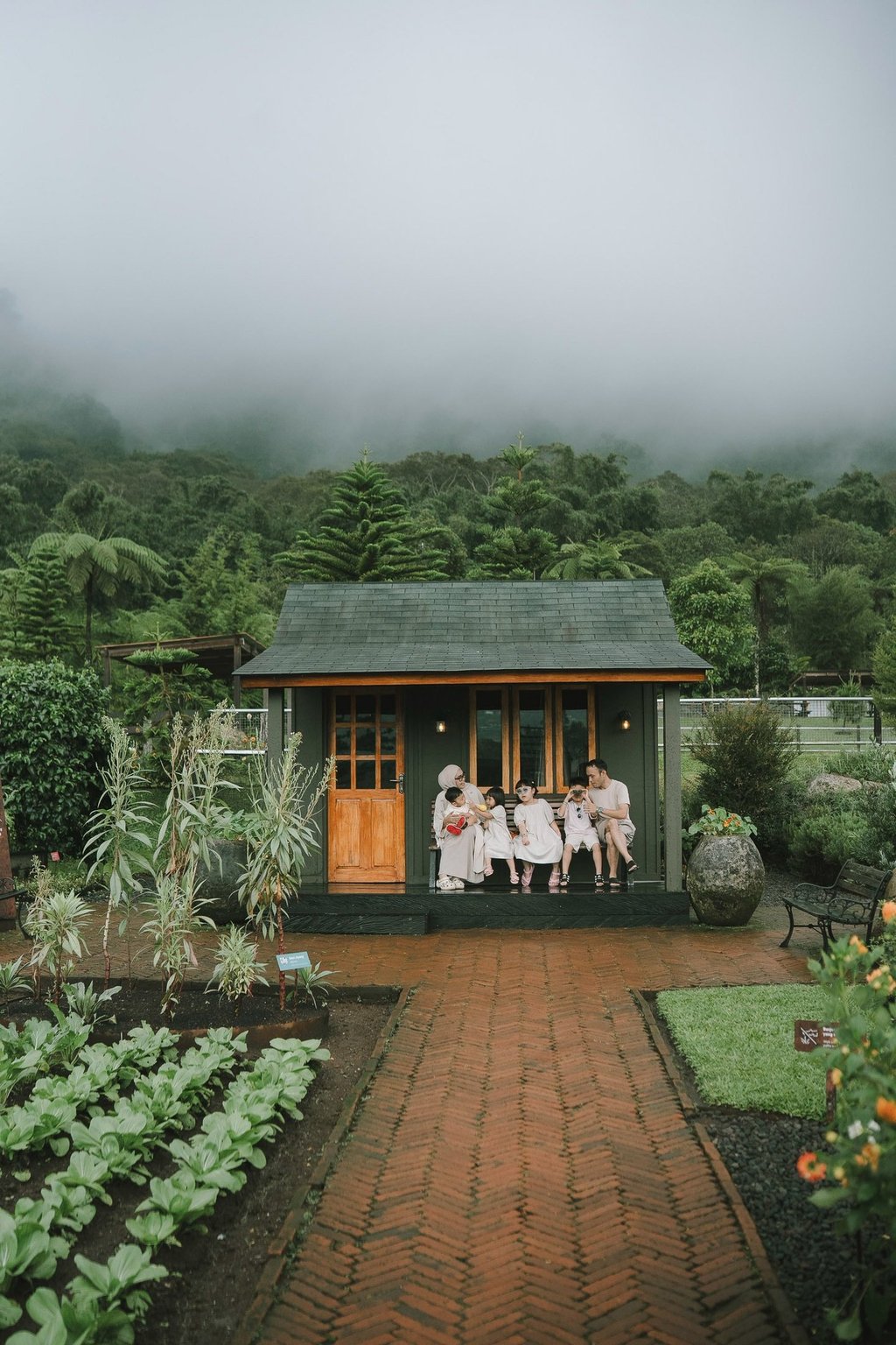 Family walking in rain during a family photography session at Rumah Gemuk Bedugul Bali.
