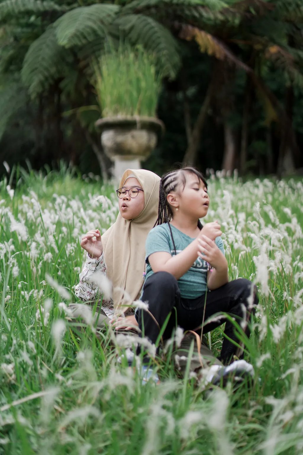 Sister and child sharing a quiet moment in an alang alang field during a Bedugul family photography session.
