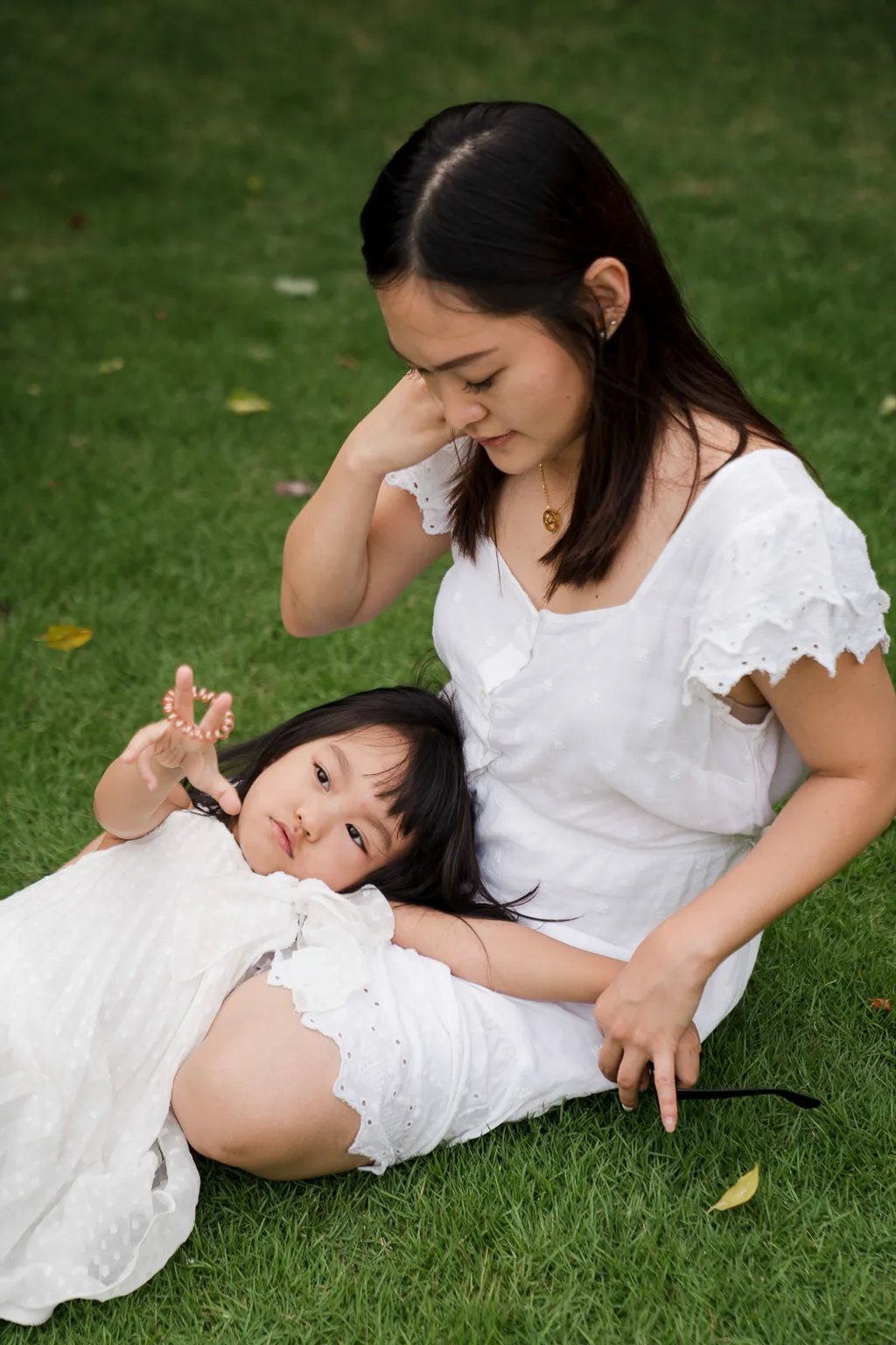 Quiet mother and child portrait on the grass at a private villa in Seminyak Bali with natural light and soft lifestyle story