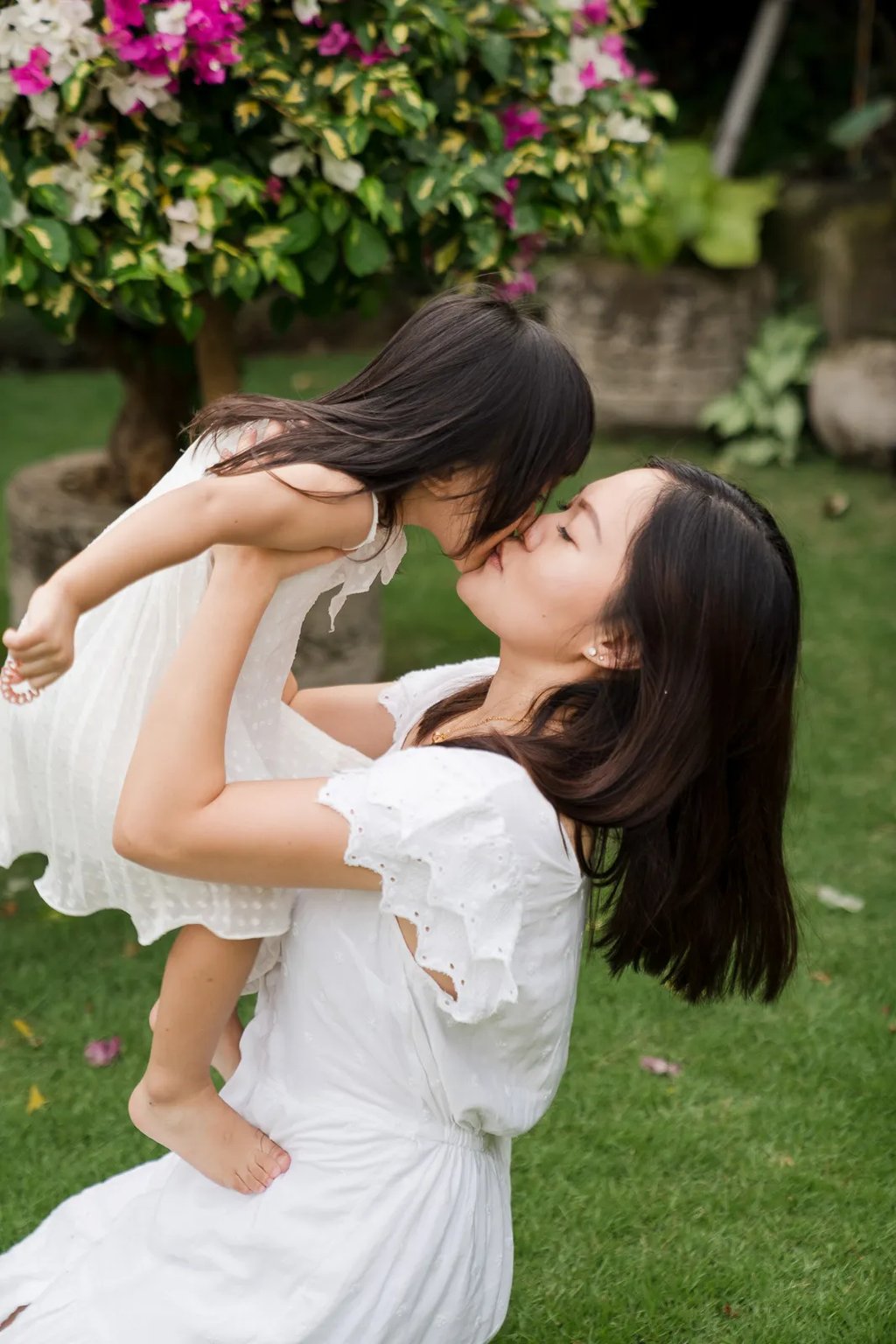 Natural mother and daughter moment captured in a tropical garden during a relaxed family photography session in Seminyak