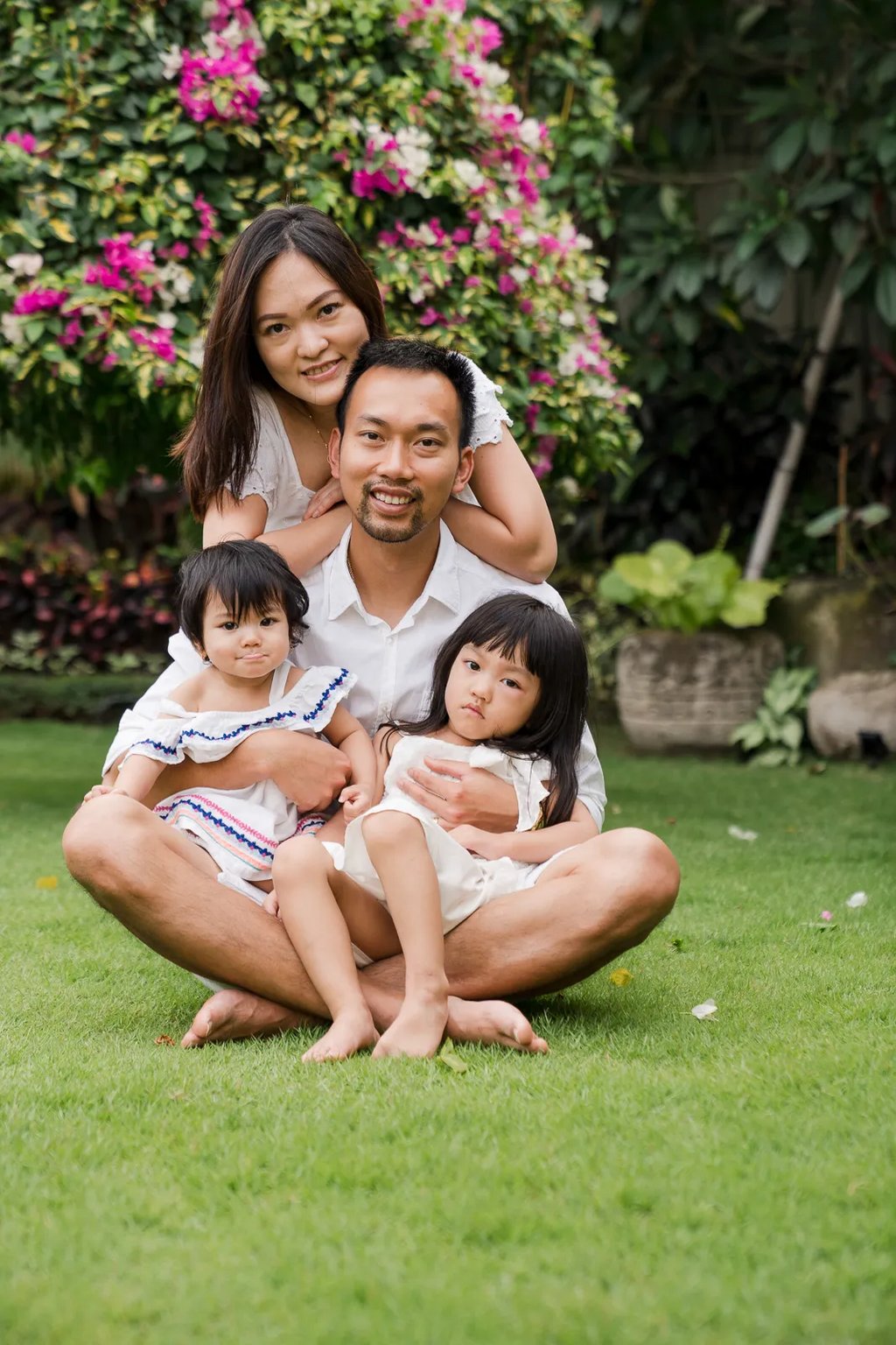 Natural family portrait in the garden of a private villa in Seminyak Bali with calm tropical surroundings and genuine