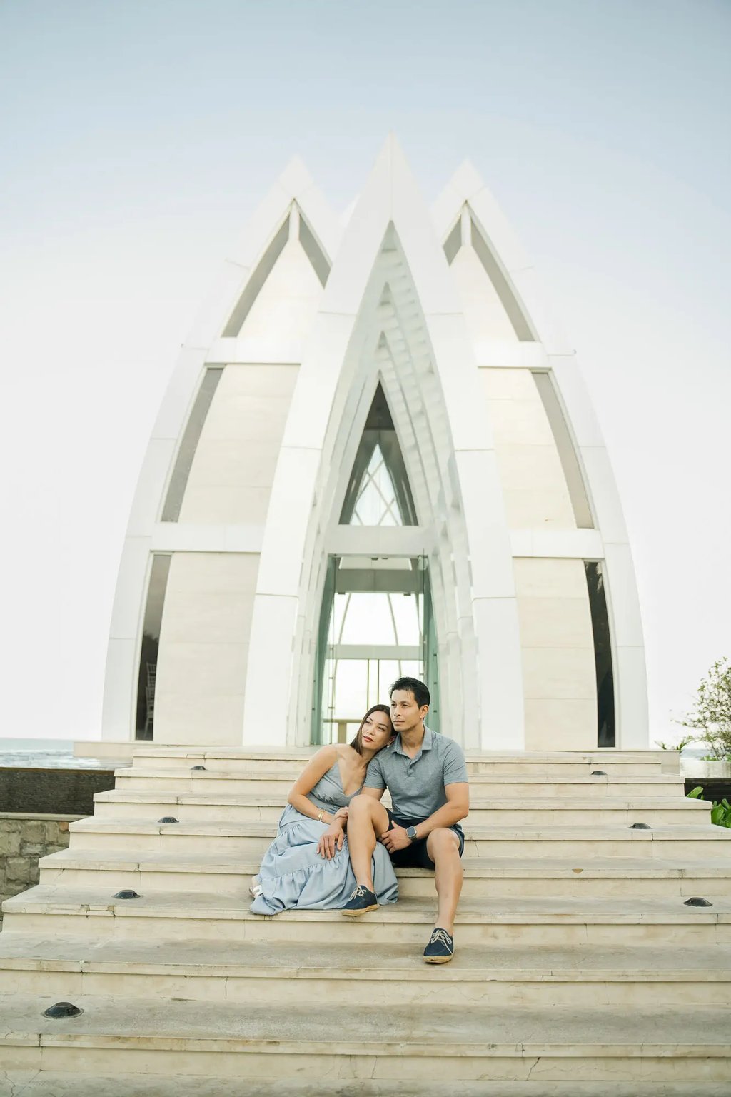 Couple sitting together in front of the chapel during a luxury family photography session at The Ritz-Carlton Bali.