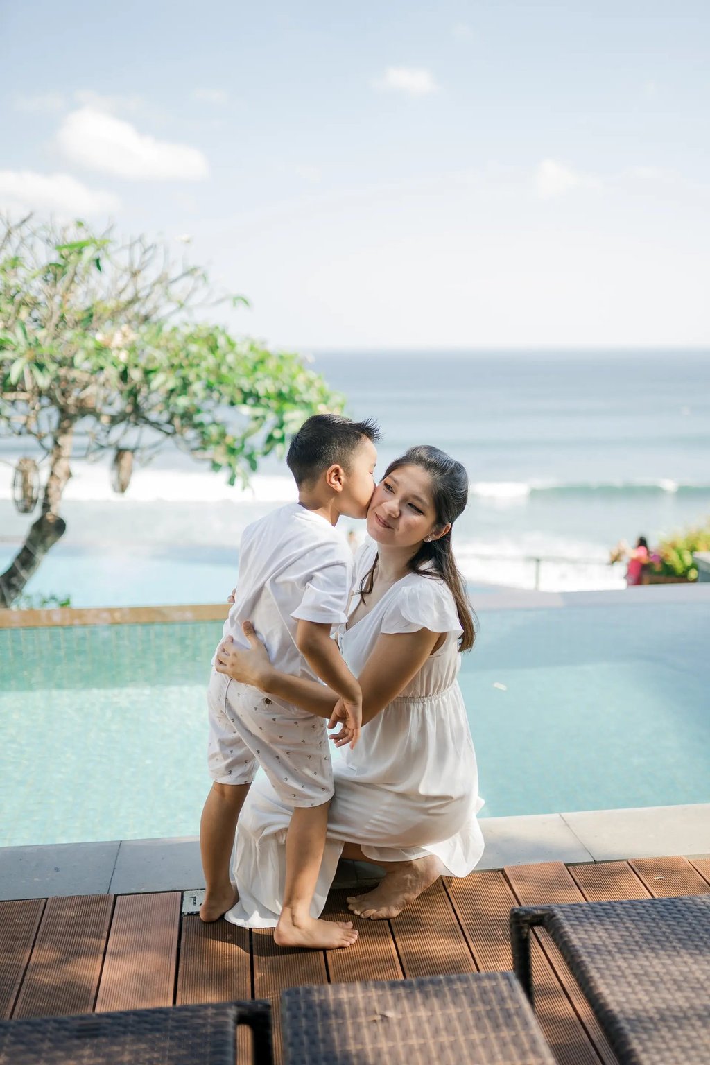 Parents sharing a quiet moment by the pool during a family session at Anantara Uluwatu.