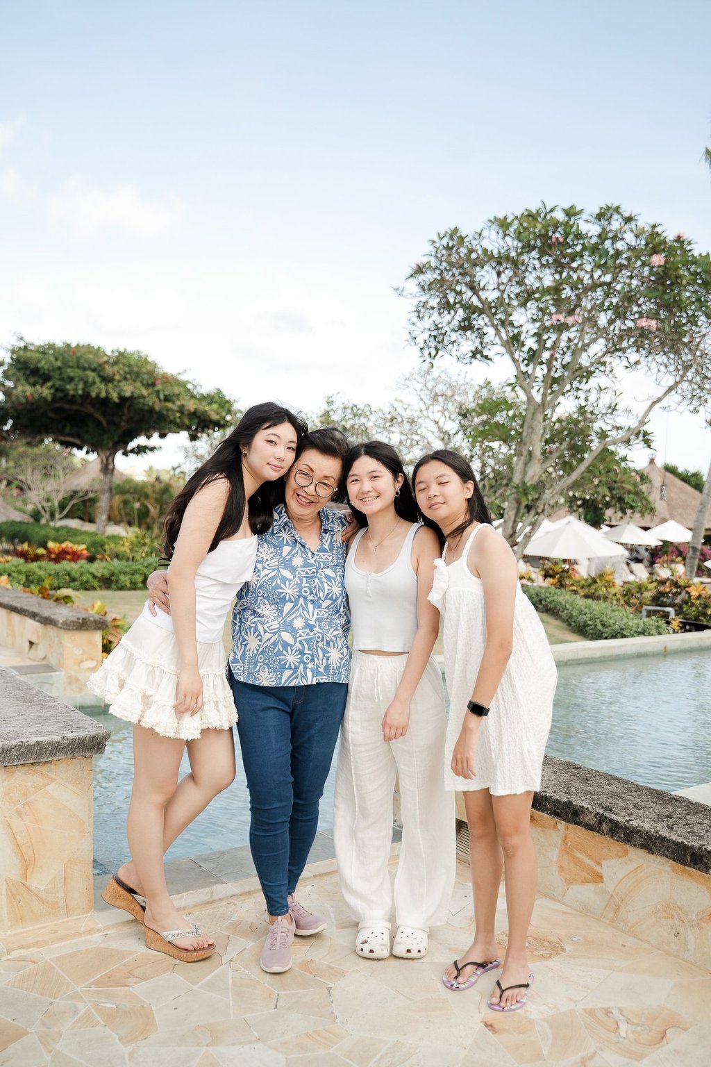 Three sisters walking together naturally during a relaxed family photography session at Ayana Jimbaran Bali