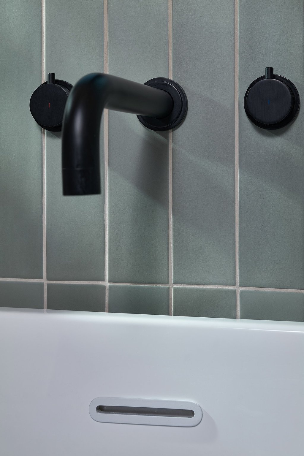 blue vertical tile with white grout and black bath tap 