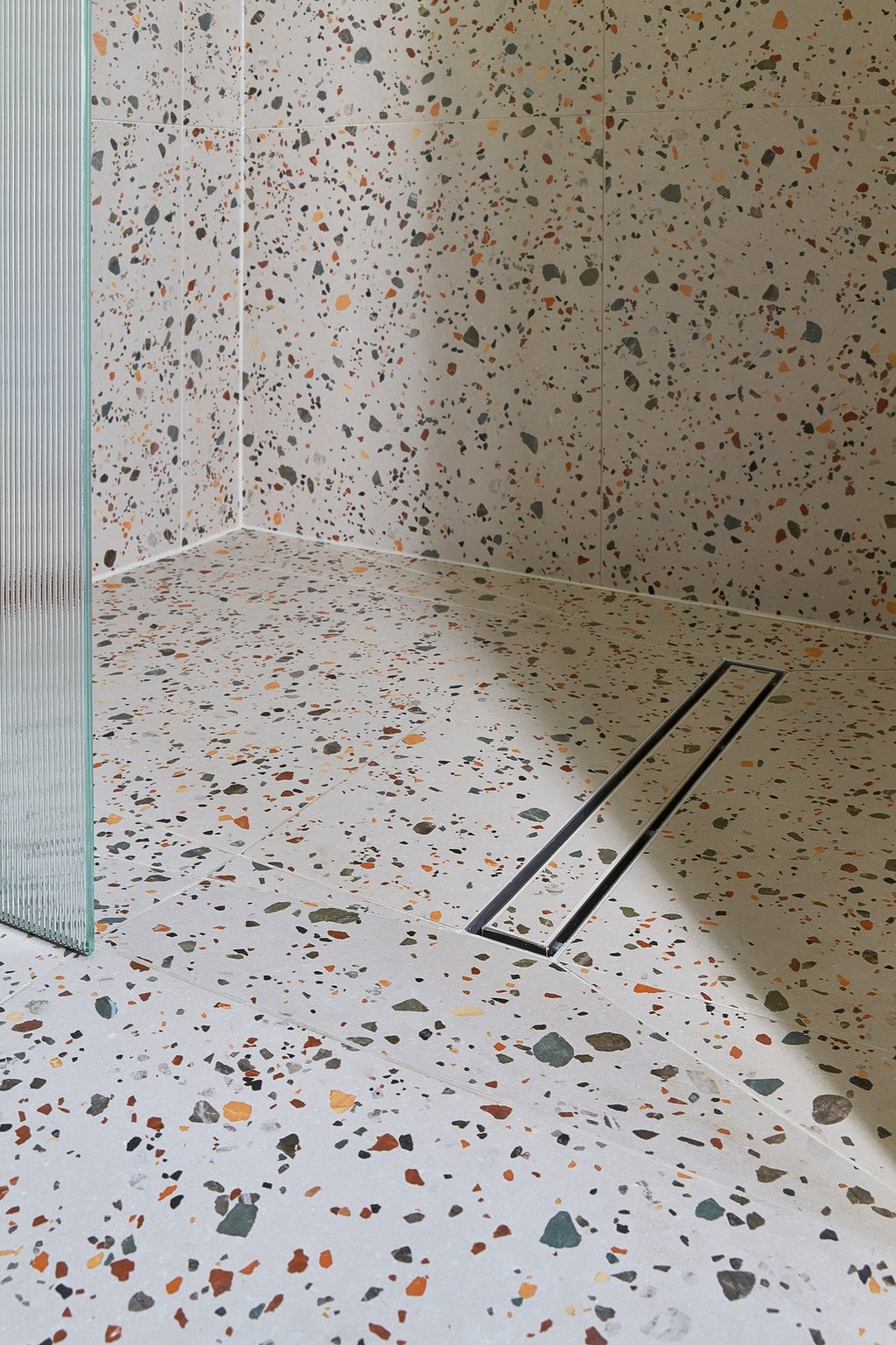large-format terrazzo tiles in a wet room with tile in shower base