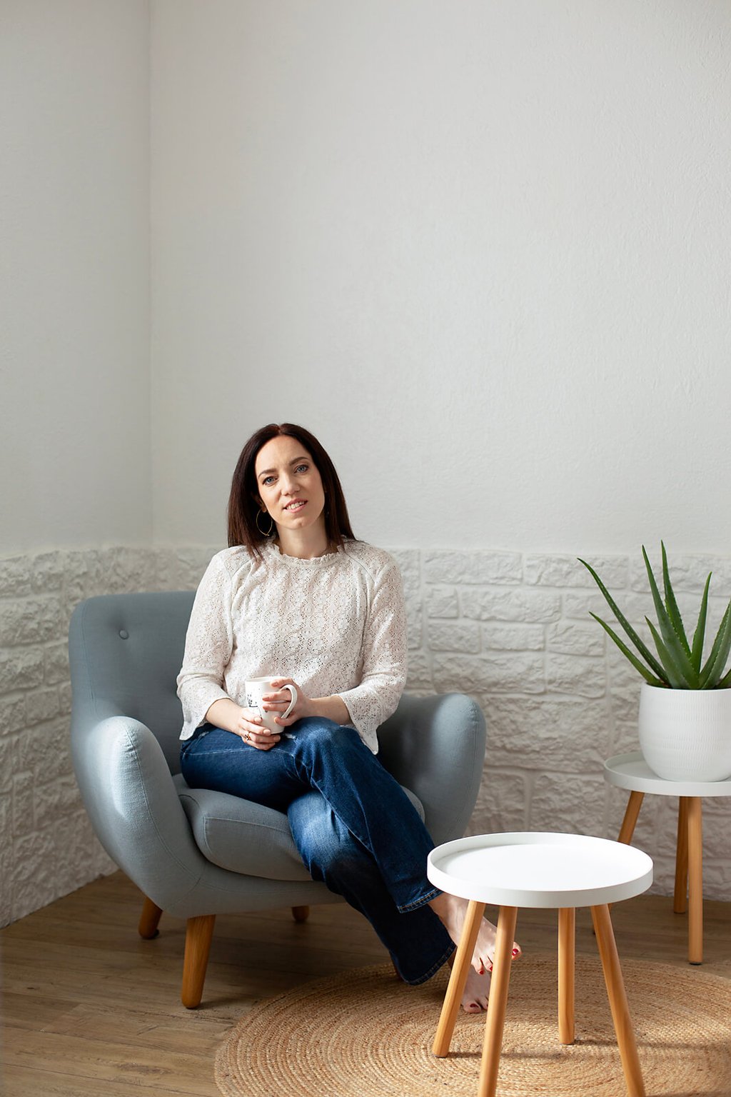 a woman sitting in a chair with a plant in front of her