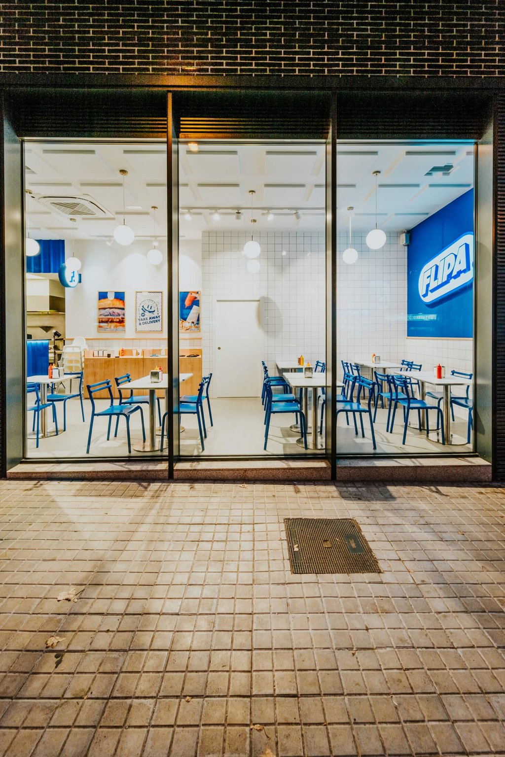 Fachada acristalada del local de Flipa con interior visible y decoración azul y blanca