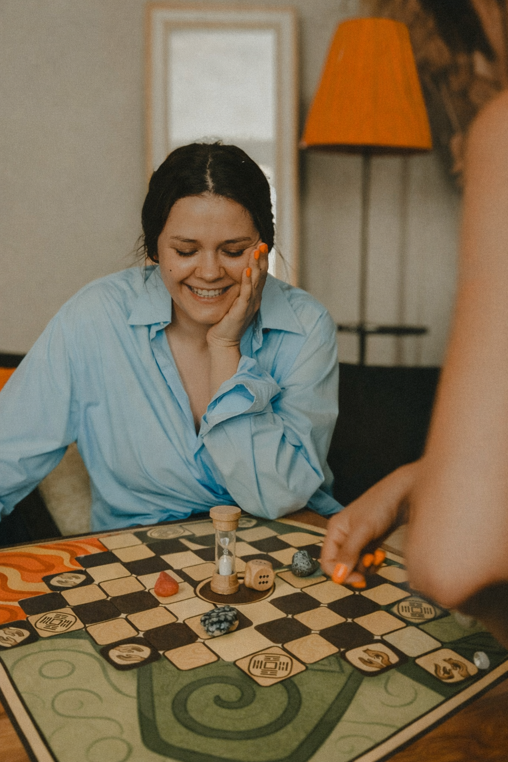 a woman sitting at a table with a game board game