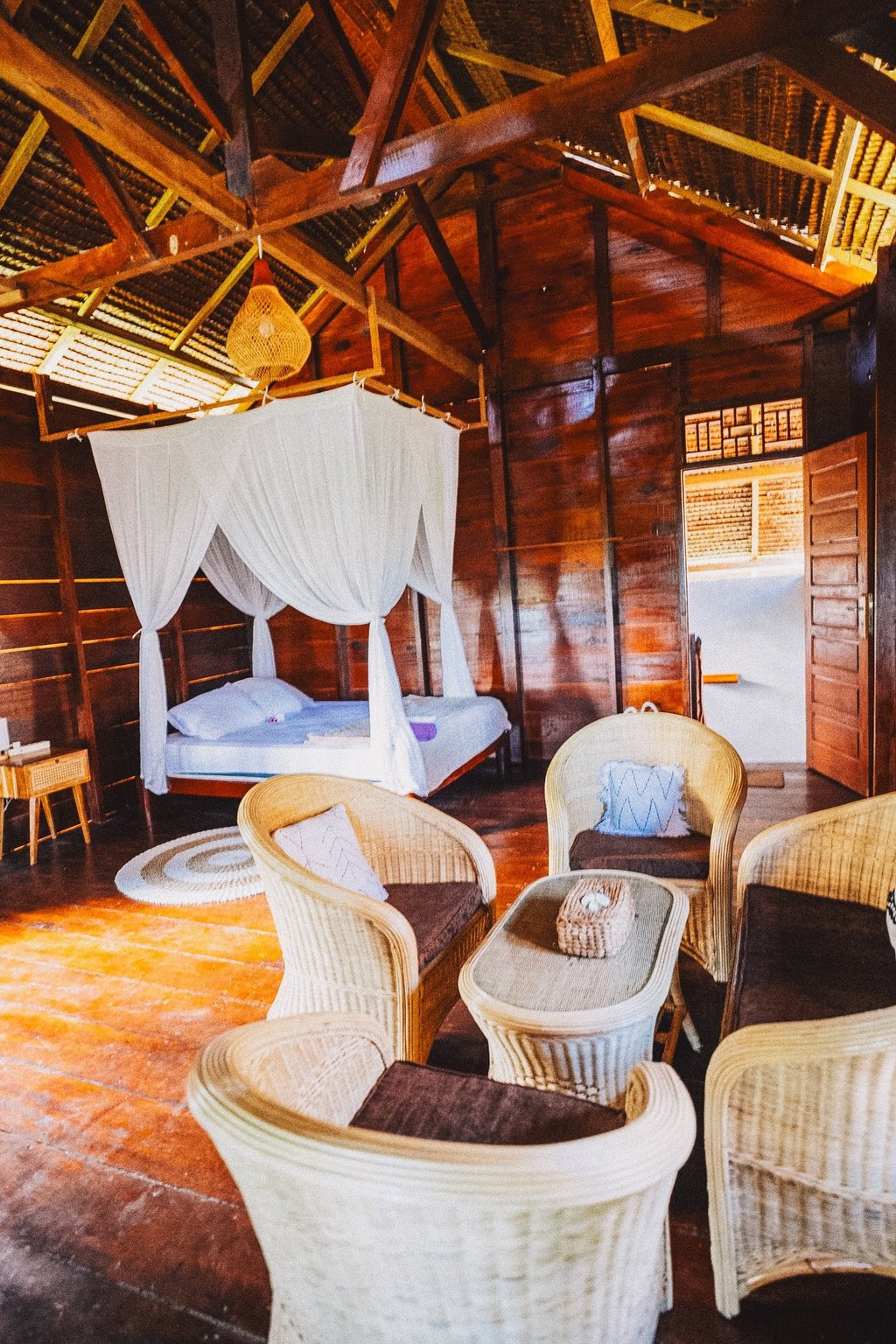 Toska bungalow bedroom with canopy bed, wooden walls, and natural light