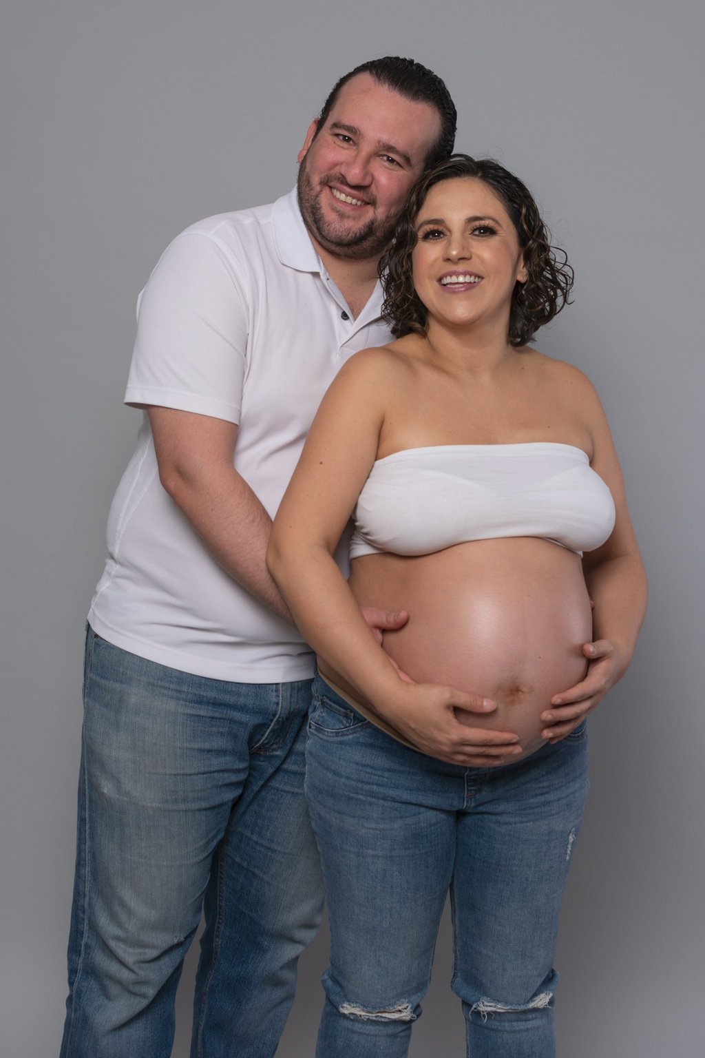 a pregnant woman and her husband are posing for a photo