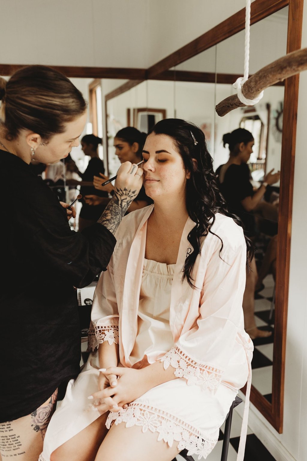 a woman getting her makeup done by a makeup artist