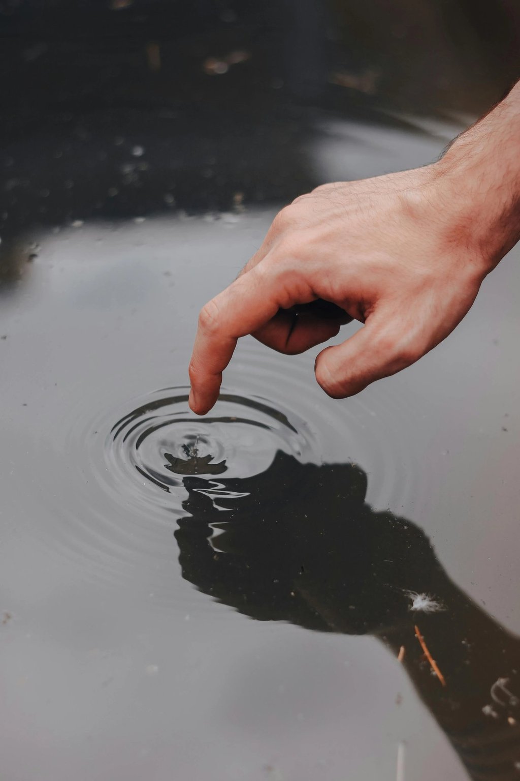 a person's hand is touching a water droplet