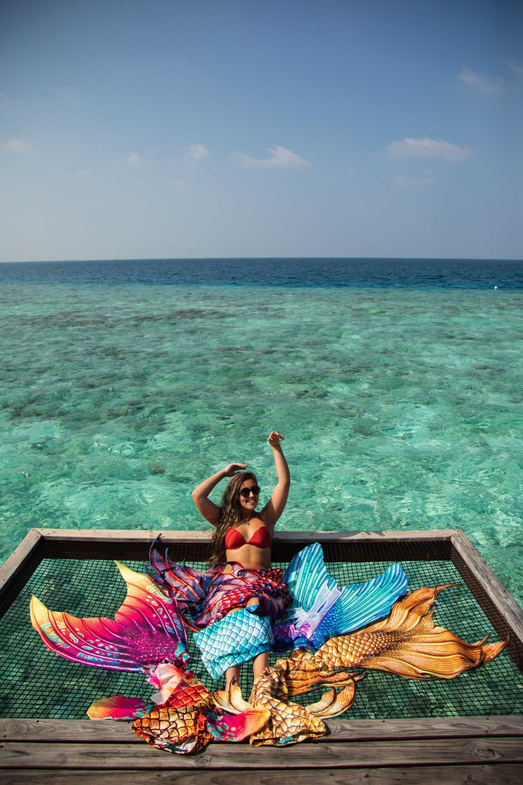 Seriea Guardia sitting on a lounge-net above the water, surrounded by her tails.