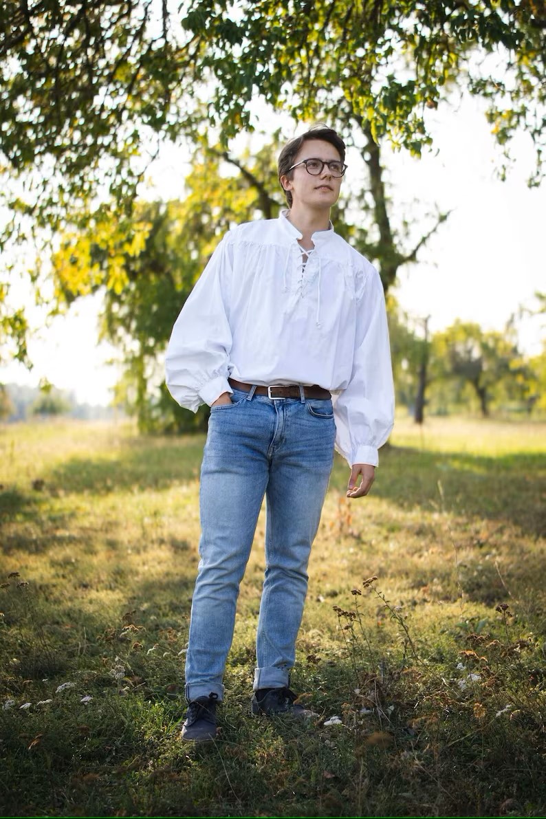 Man in blue jeans wearing an eighteenth century style mens shirt.