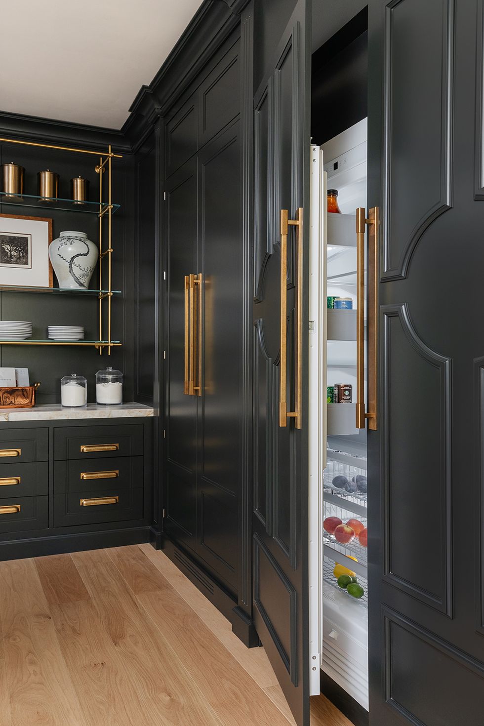 a kitchen with black cabinets and gold accents
