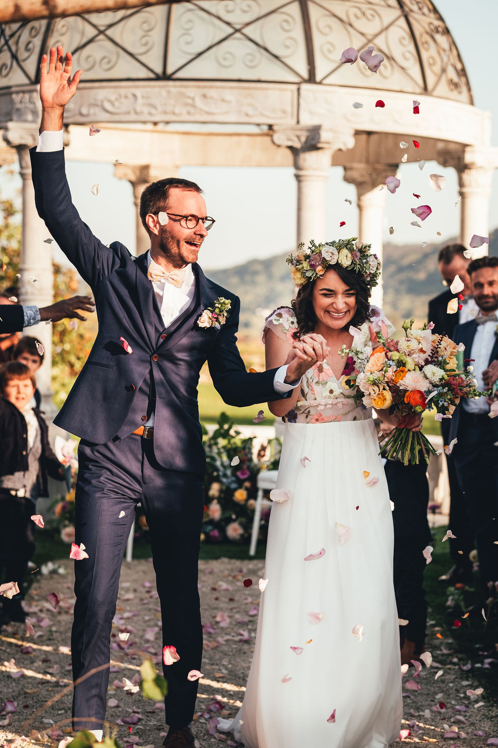mariés heureux sous pluie de pétales