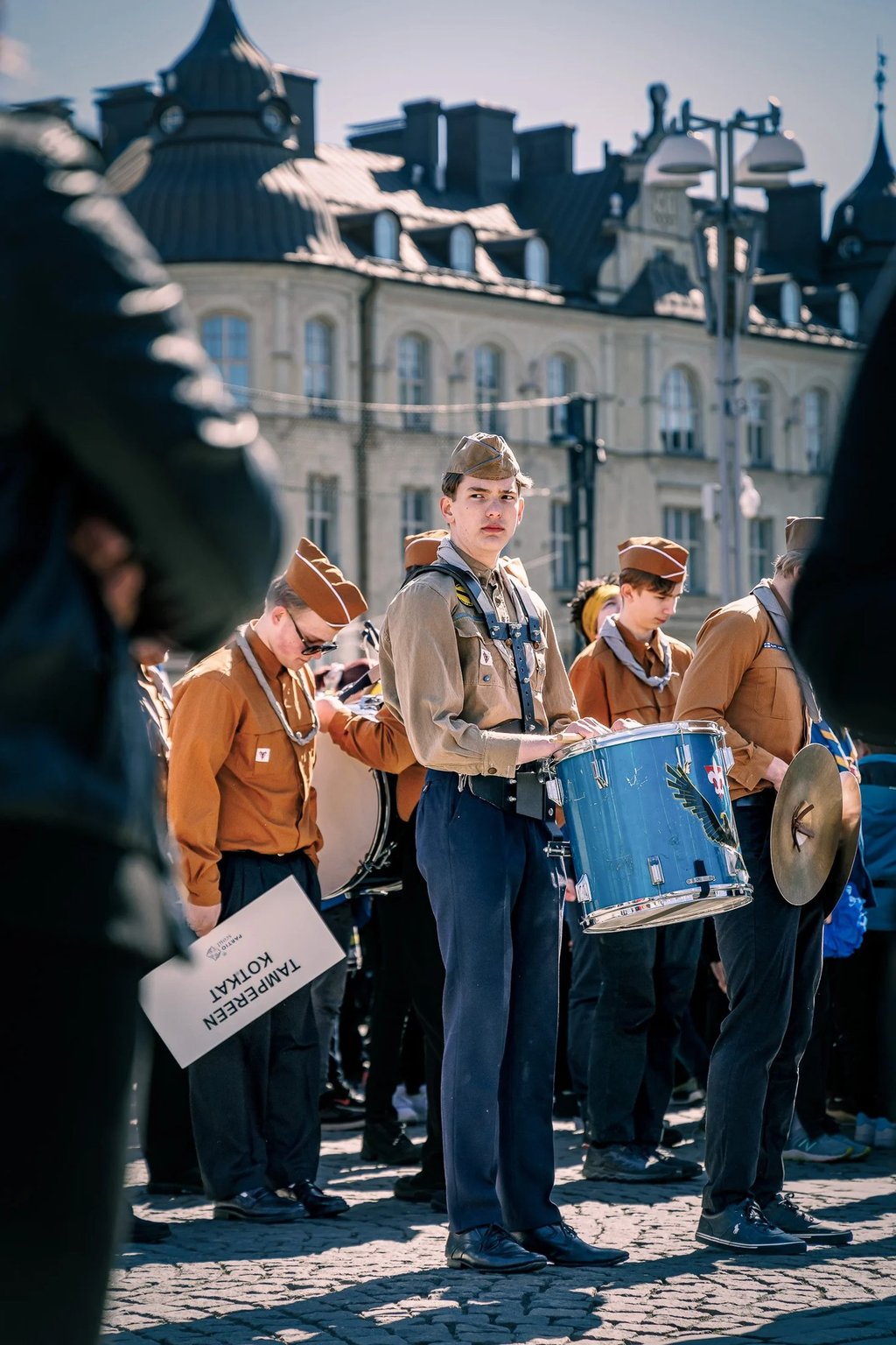 a man in a uniform is holding a drum and a drum
