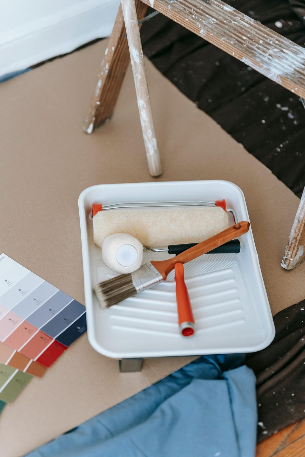 a paint roller brush and paint brushes on a table