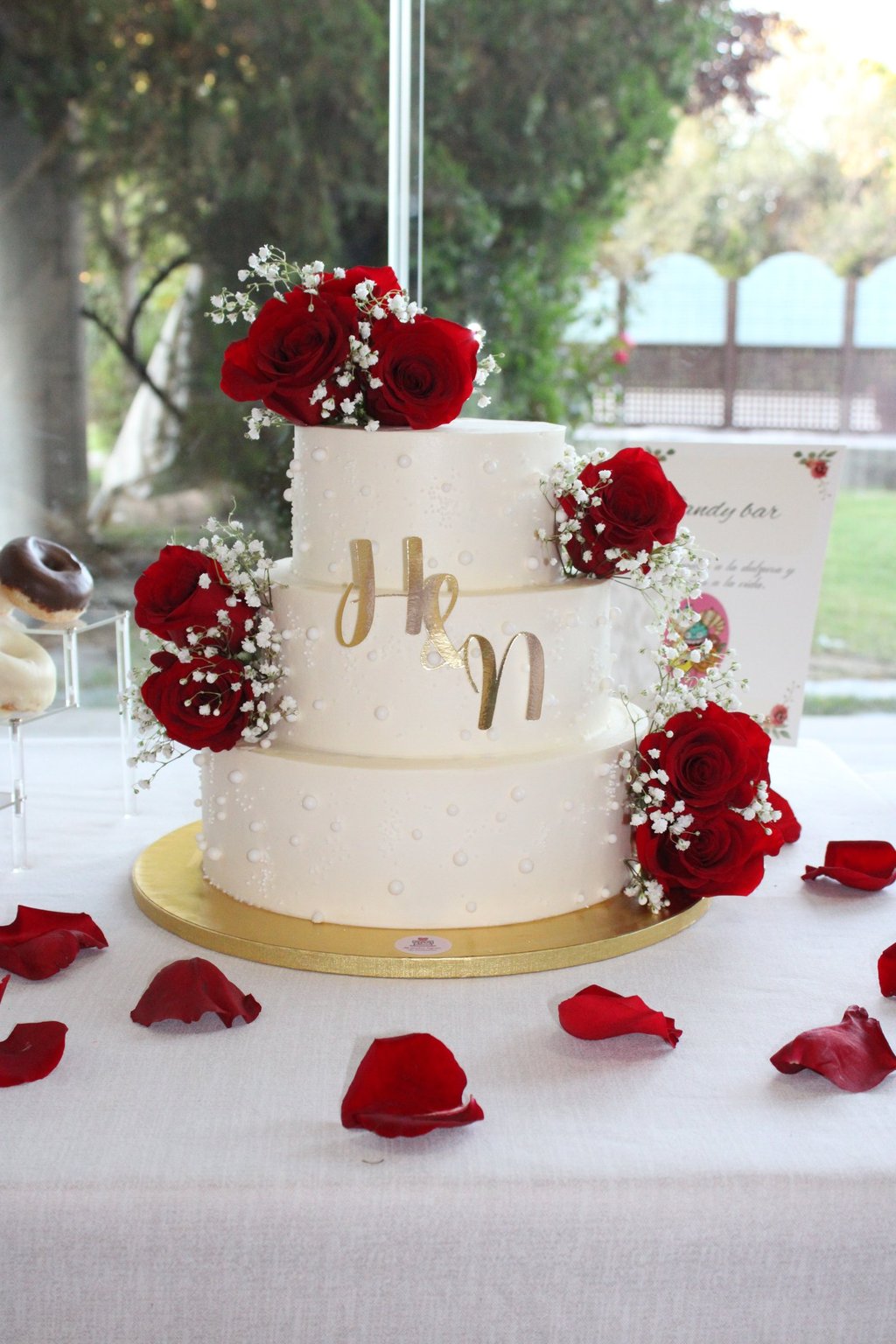 Tarta de boda elegante con rosas rojas y decoración romántica, creada en Madrid