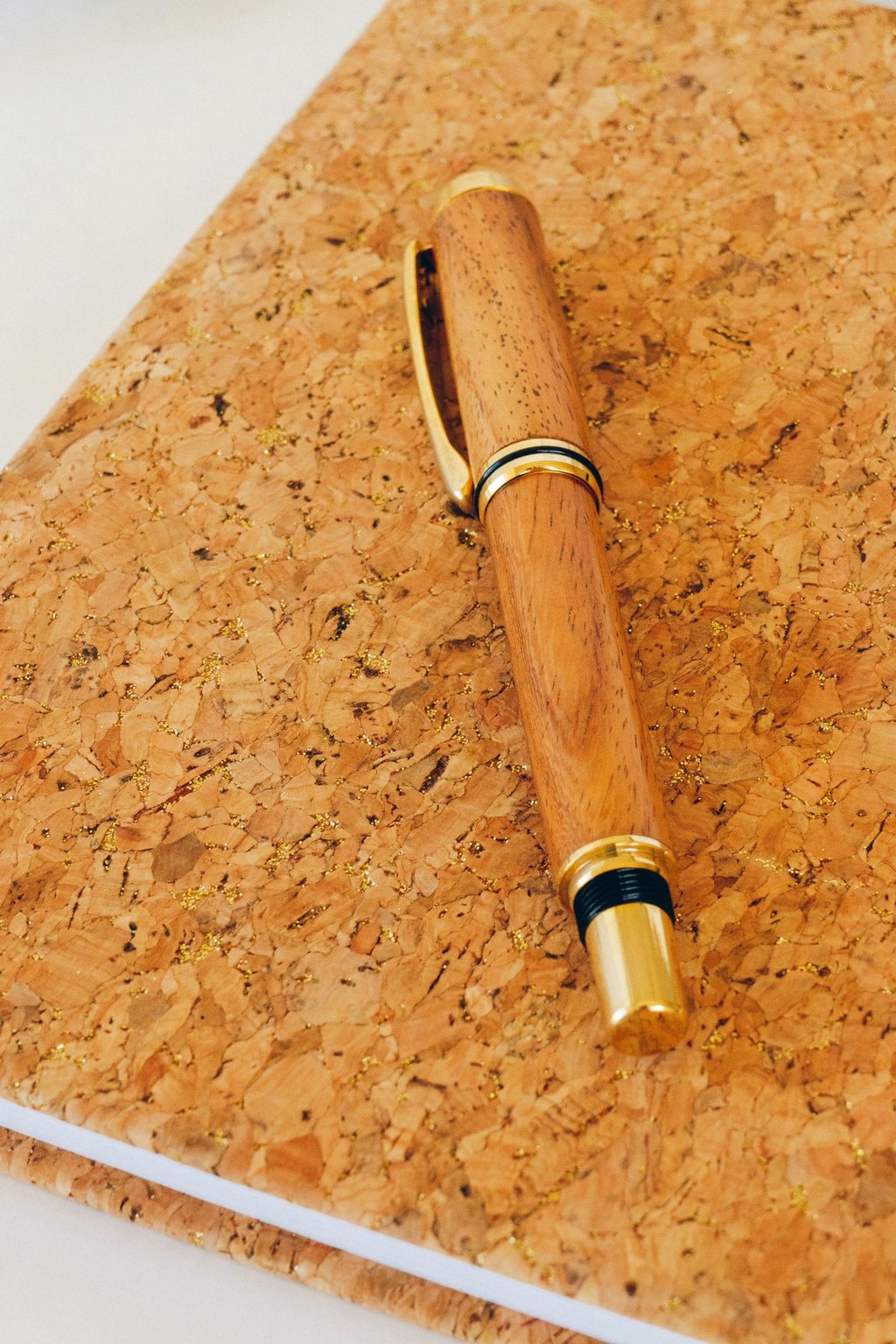 Close-up photo of a wooden pen on a cork background. Credit Ania Archer via Unsplash.