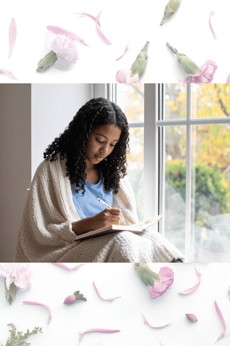 Teenage girl wrapped in a blanket journaling by a window, showing a calm self-care moment.