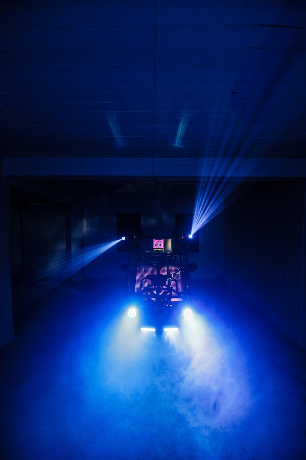 Professional DJ setup with blue stage lights and fog machine effects in a dark event venue.