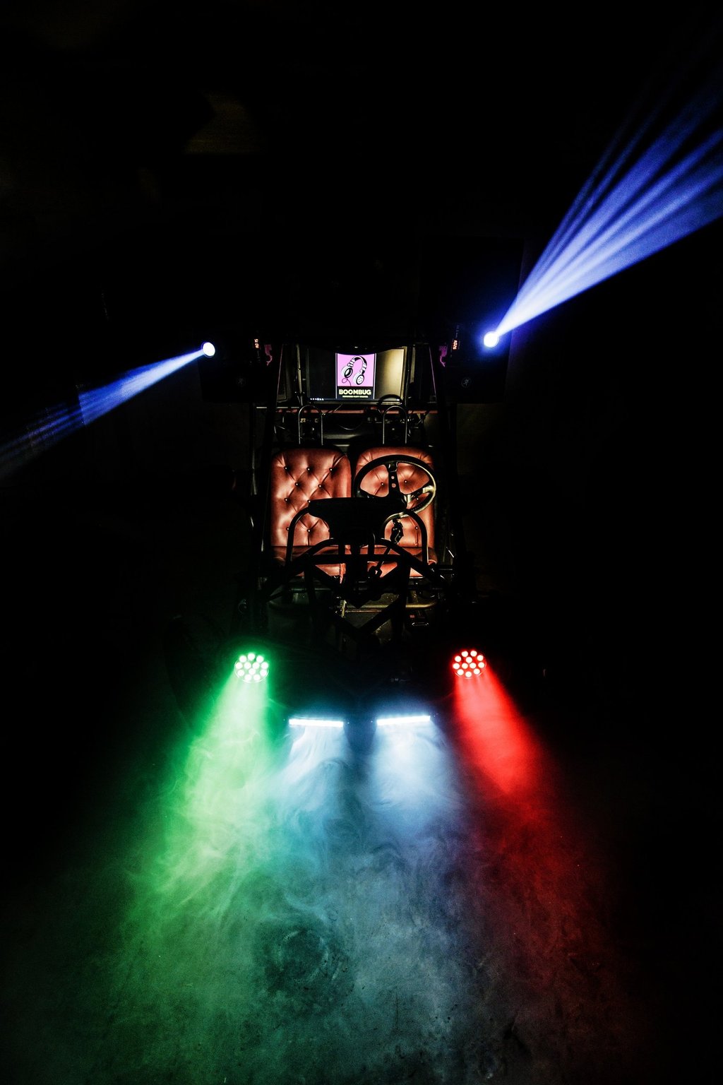 Custom Mobile Dj buggy with colorful LED light show and fog machine in a dark garage.