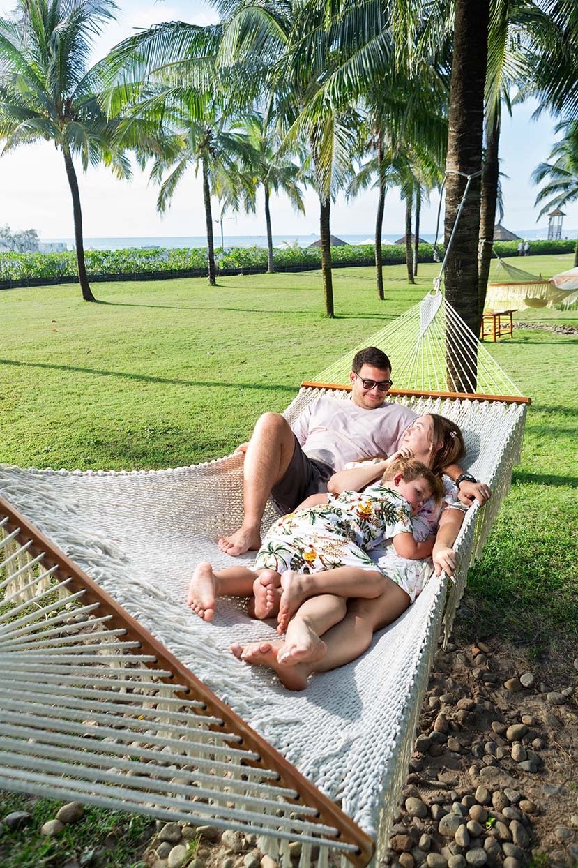 Семья отдыхает в гамаке под пальмами в Radisson Blu Resort Phu Quoc