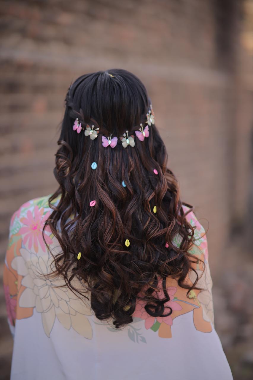 Whimsical open curls hairstyle decorated with colorful butterfly clips for engagement or pre-wedding