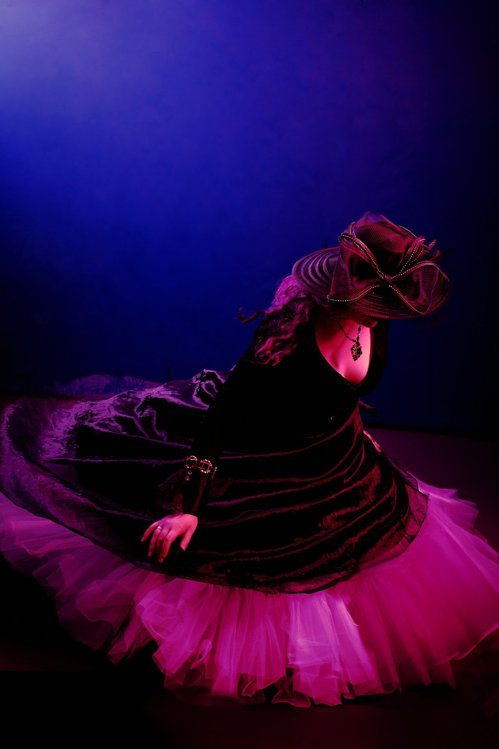 a woman in a black dress and fancy hat dancing around