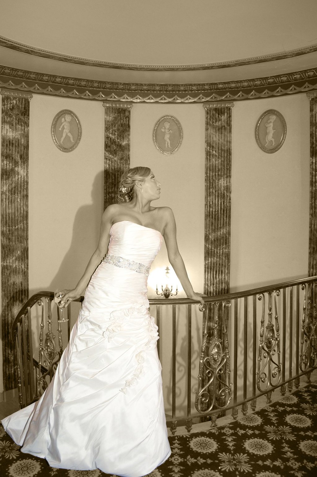 a bride in a strapless white dress posing in the hotel lobby