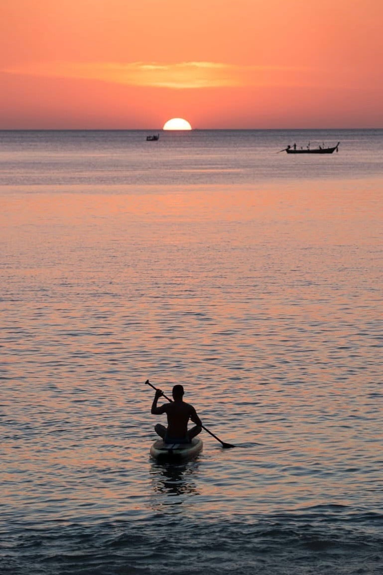 Travel writer Rick Silvia paddles into the sunset by kayak in the bay of Bang Tao