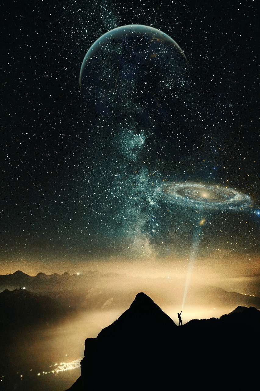 a person standing on a mountain top with a view of a galaxy