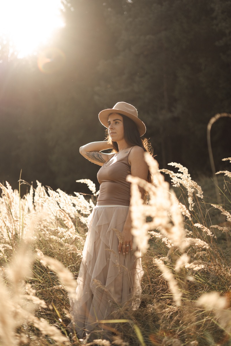 Woman standing on the field during sunset