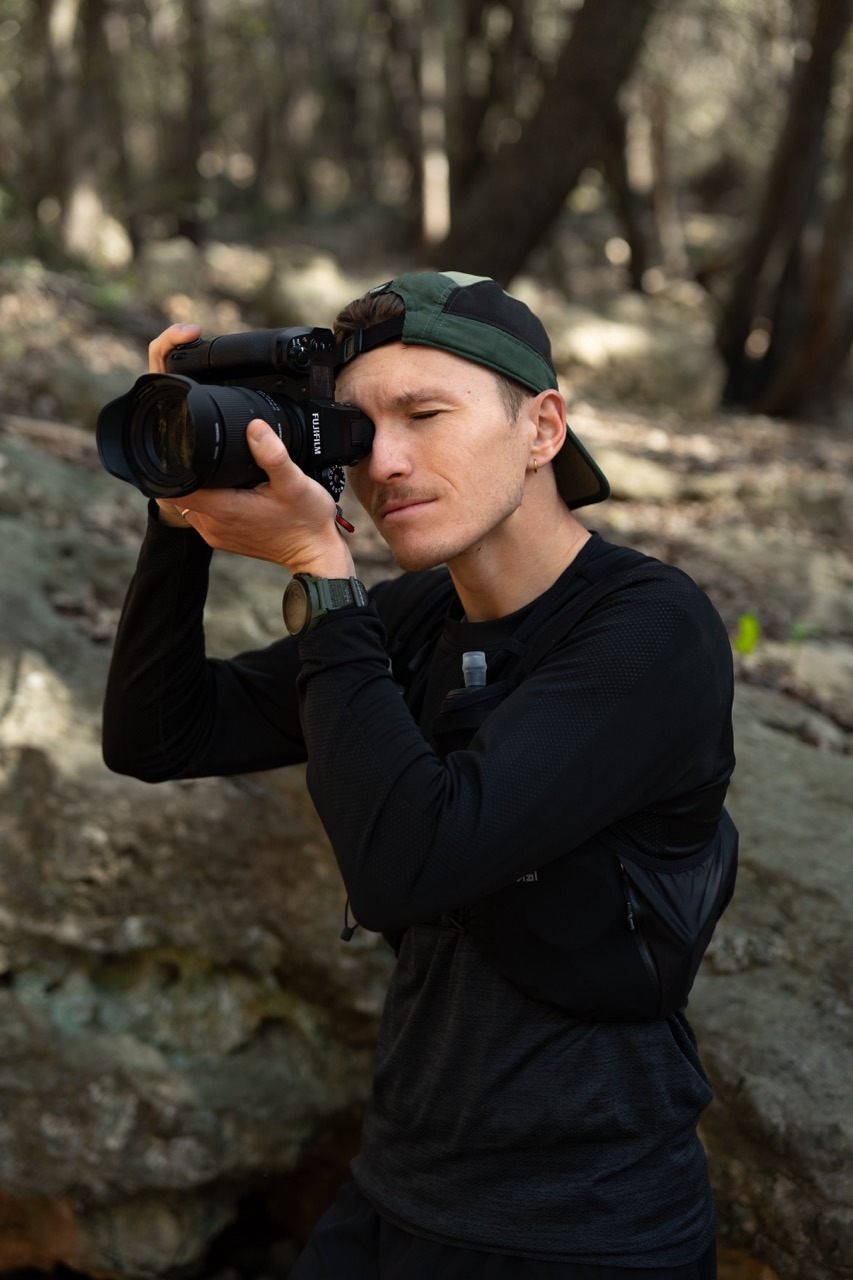 a man taking a picture of himself in the woods