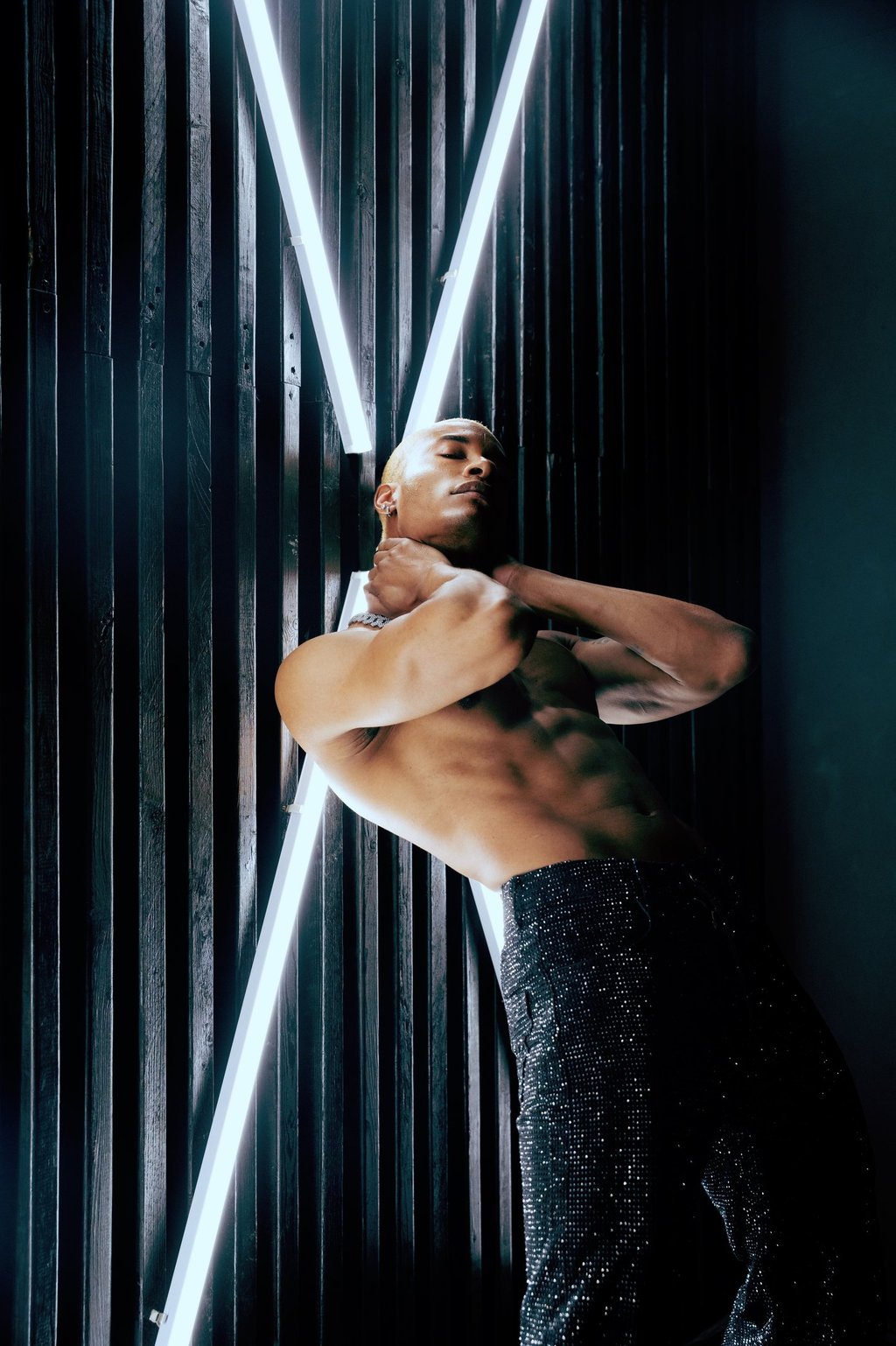 Roy Covington shirtless leaning against the wall