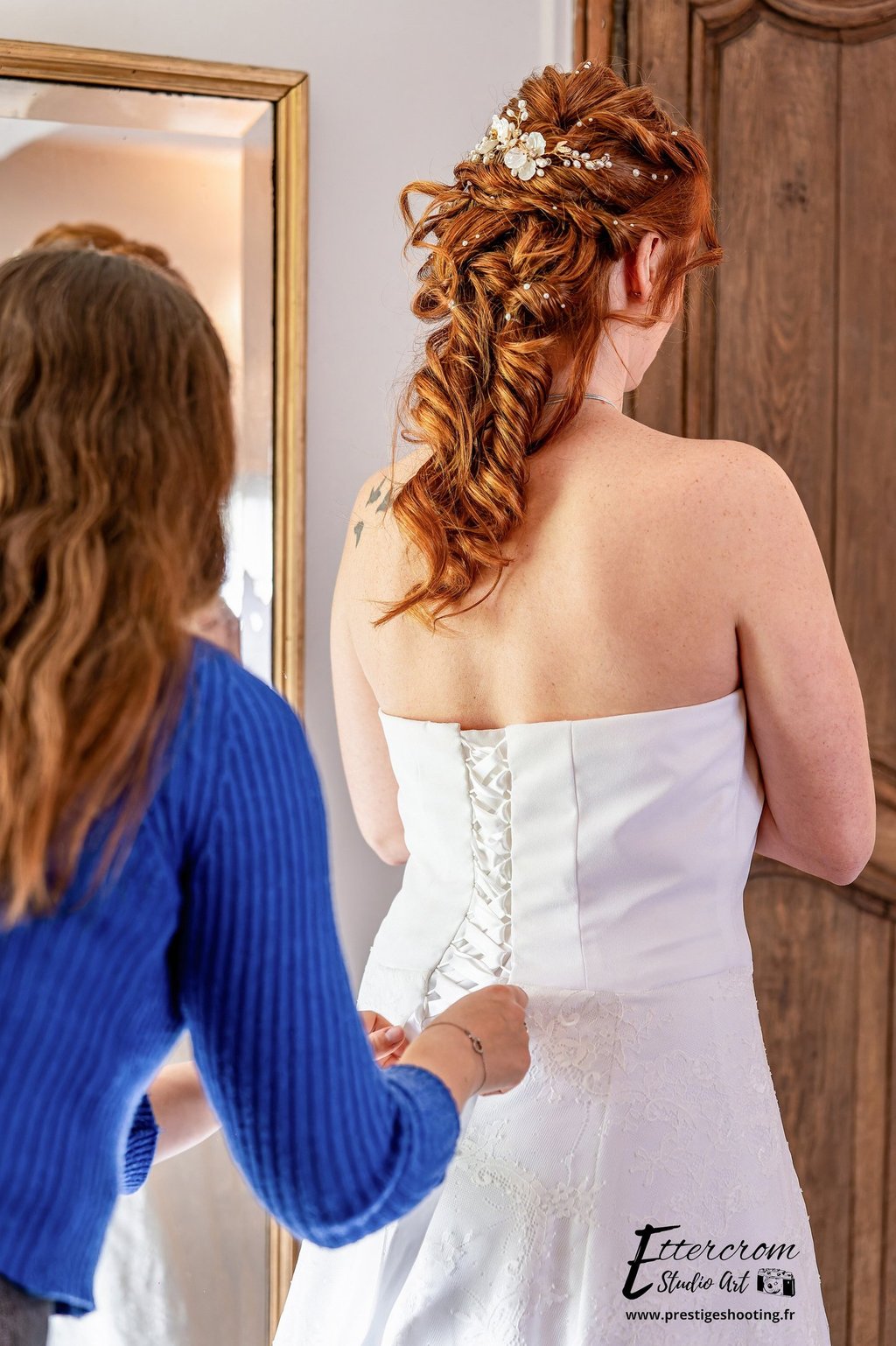 a woman in a wedding dress is looking at her reflection in the mirror