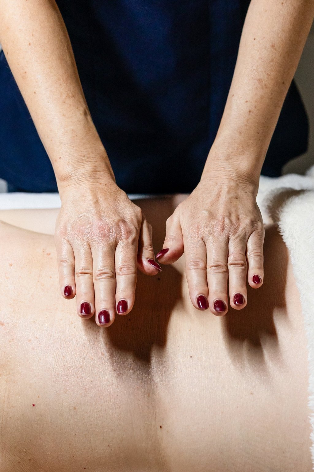 Nathalie Gaullier pose ses mains sur le dos de sa cliente pour faire un massage harmony bien-être